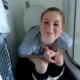 A British girl is filmed pooping on a toilet by her friend. The scene is brief, and no pooping sounds can be heard.